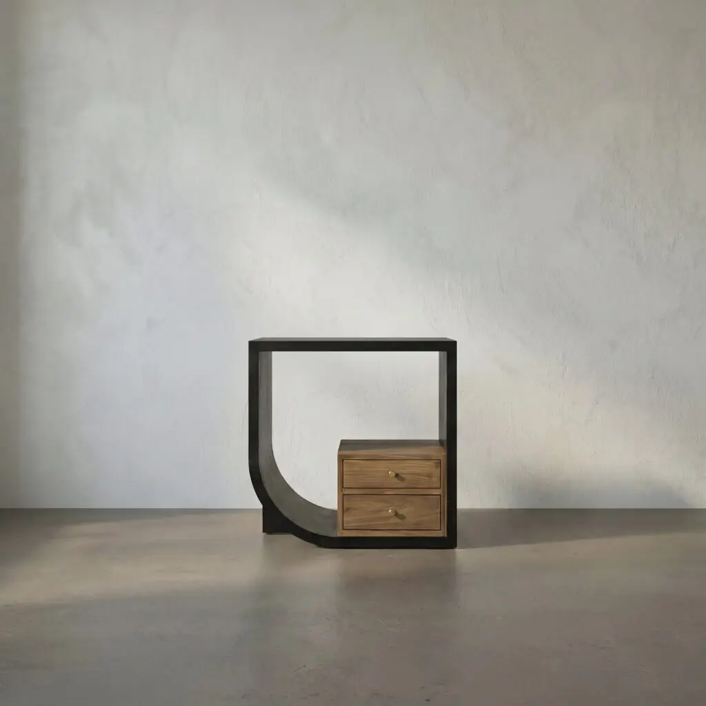 Sculptural black metal frame with three wooden drawers, set against a plain gray textured wall.