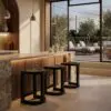 Wood-and-stone bar area with pendant lamps and a glass wall showing an outdoor seating space and string lights.