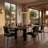 Modern dining room with a long wooden table, black chairs, and a large dome pendant light; windows reveal trees outside in warm evening light.