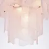 Close-up of pale pink, glossy drips hanging down a surface against a light background in an abstract, gel-like sculpture size.