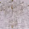 Crystal chandelier with translucent square glass prisms and gold metal supports (close-up).