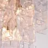 Close-up of a crystal chandelier with stacked clear glass cubes reflecting warm light.
