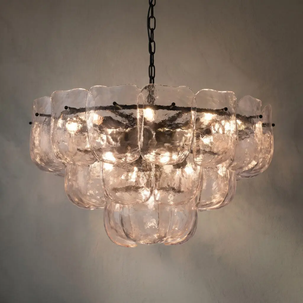 Chandelier with several clear glass bowls hanging from a metal ring, softly illuminated bulbs inside.
