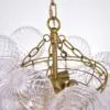 Close-up of a gold chandelier frame with clear textured glass bulbs hanging from chains.