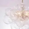 Decorative chandelier with clear ribbed glass globe shades hanging from a gold chain.