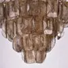 Close-up of a cascading chandelier made from overlapping translucent brown teardrop glass pieces.