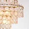 Gold chandelier made of overlapping circular shells hanging from a chain