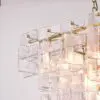Modern chandelier with a gold frame and clear glass square prisms hanging from a chain, close-up view