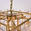 Close-up of a gold chandelier with a circular frame and clear crystal prisms around the rim.