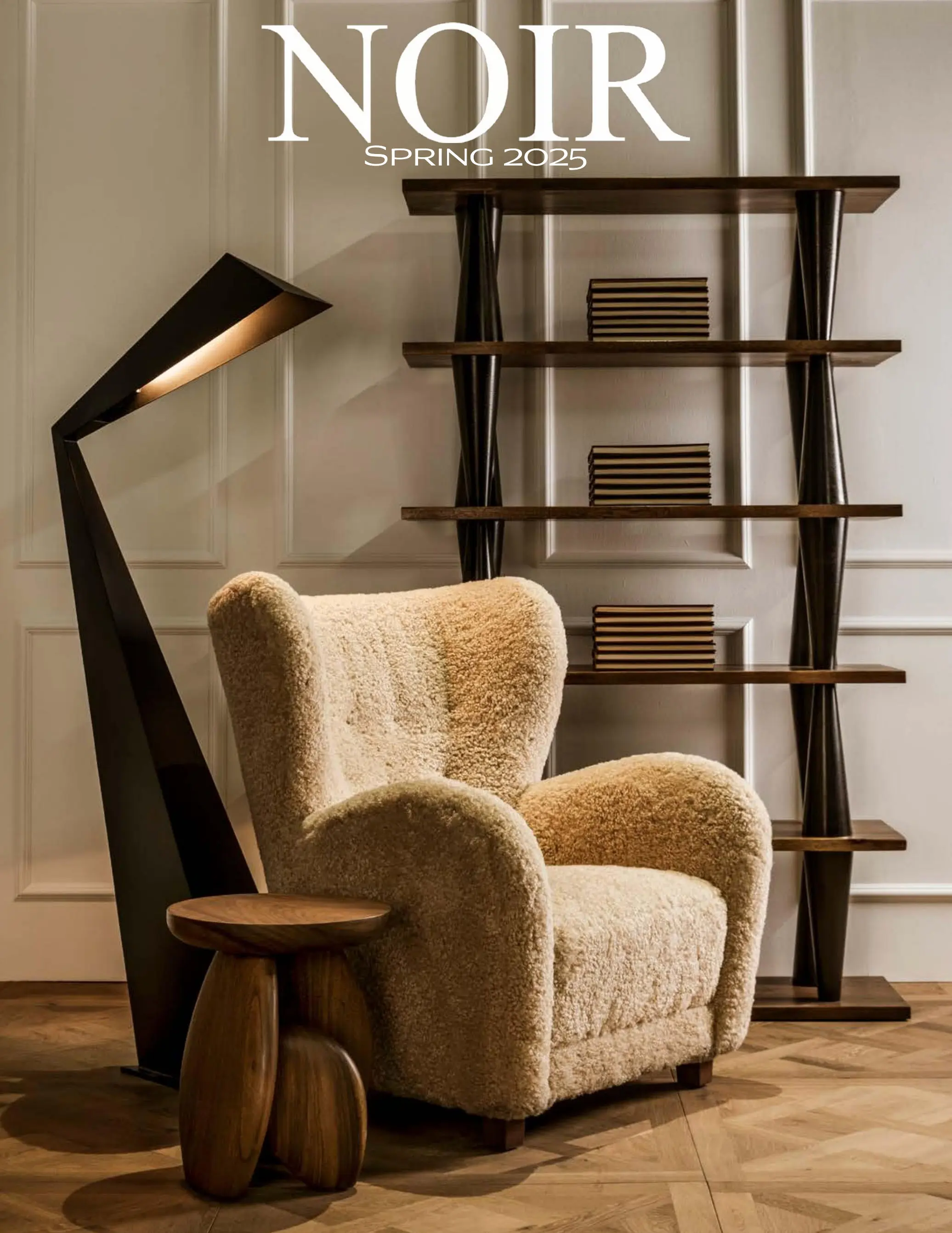 Cozy reading corner with a plush beige chair, circular wood side table, and a tall dark-wood shelf unit against paneled walls.