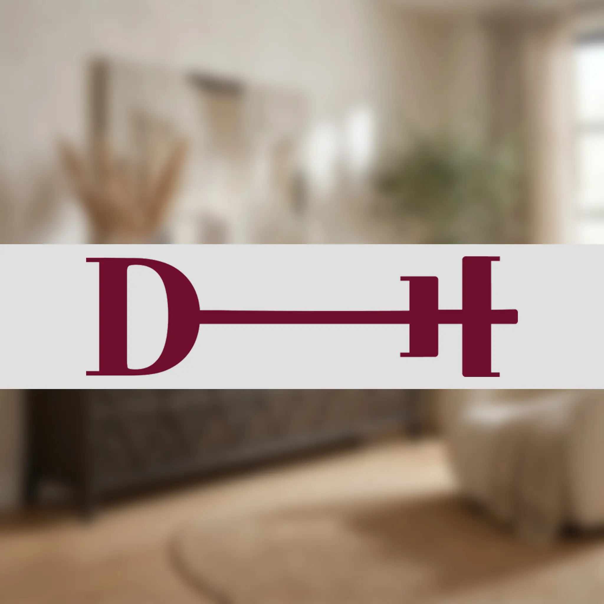 Blurry indoor scene with warm beige walls and large burgundy letters at the bottom edge.