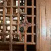Close-up of a dust-coated decorative wooden lattice with square grid and a central carved flower motif