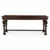 Long, dark carved wooden table with ornate spiral legs set against a white background, photographed from the side.