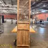 Tall wooden decorative screen with a geometric lattice panel standing in a spacious warehouse showroom.