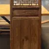 Carved wooden room divider with a geometric lattice pattern on a table in a workshop space.