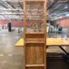 Tall wooden cabinet with a woven lattice door in an industrial warehouse setting.