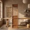 Rustic interior featuring a tall wooden cabinet, a woven wall hanging to its left, and ceramic vessels on a shelf to the right, bathed in warm light.