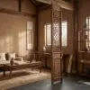 Traditional Asian-inspired interior with a carved wooden lattice screen, a wooden desk, and ceramic vases in a warm beige room.