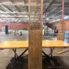 Tall carved wooden screen with a geometric lattice pattern, mounted on a pedestal in an open warehouse or workshop space.