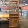 Tall wooden room divider with a geometric lattice panel in an empty industrial warehouse